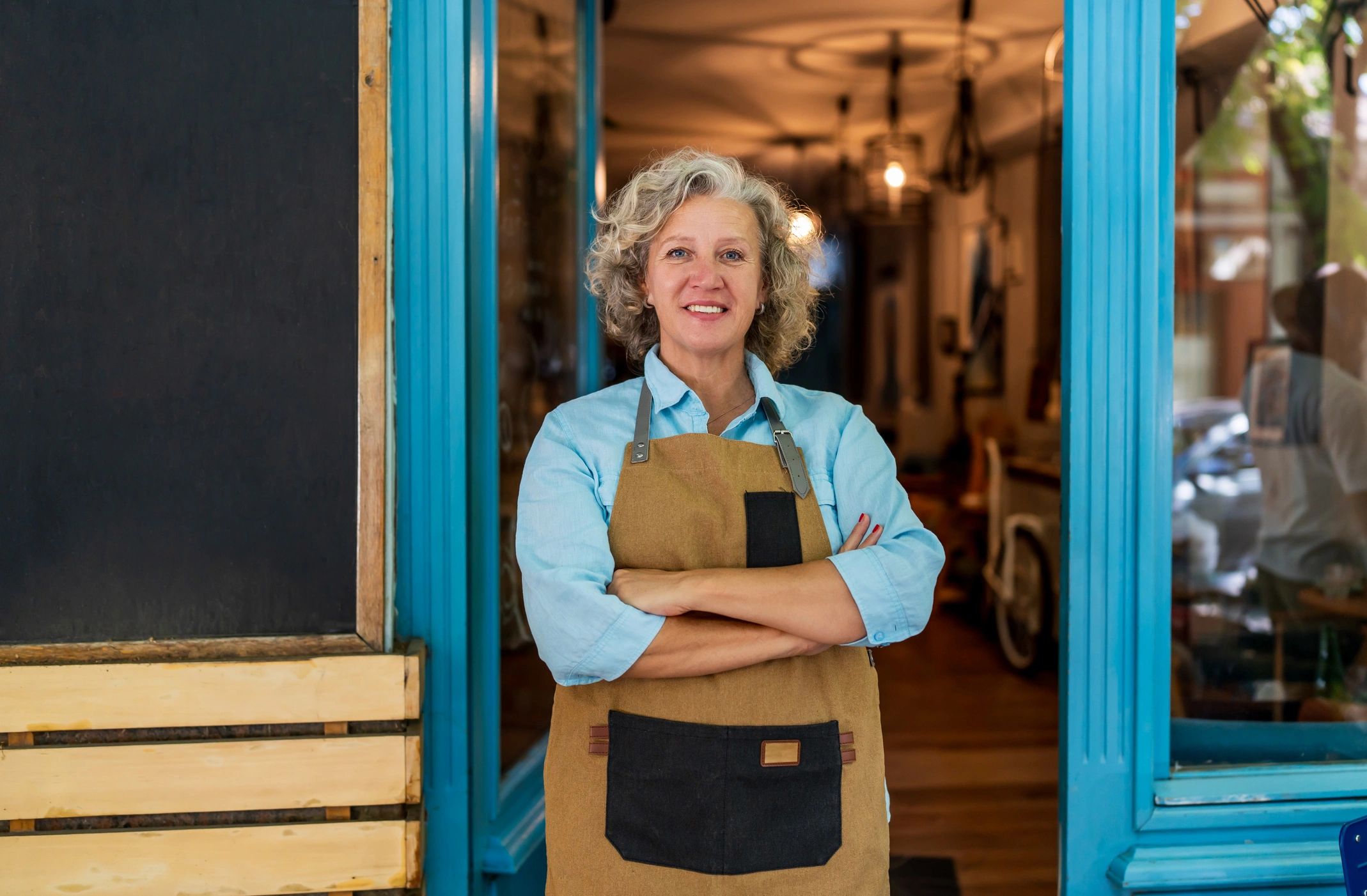 Small business owner standing at the entrance of her cafe
